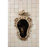 A carved polychrome wooden mirror with floral design, 19th C.