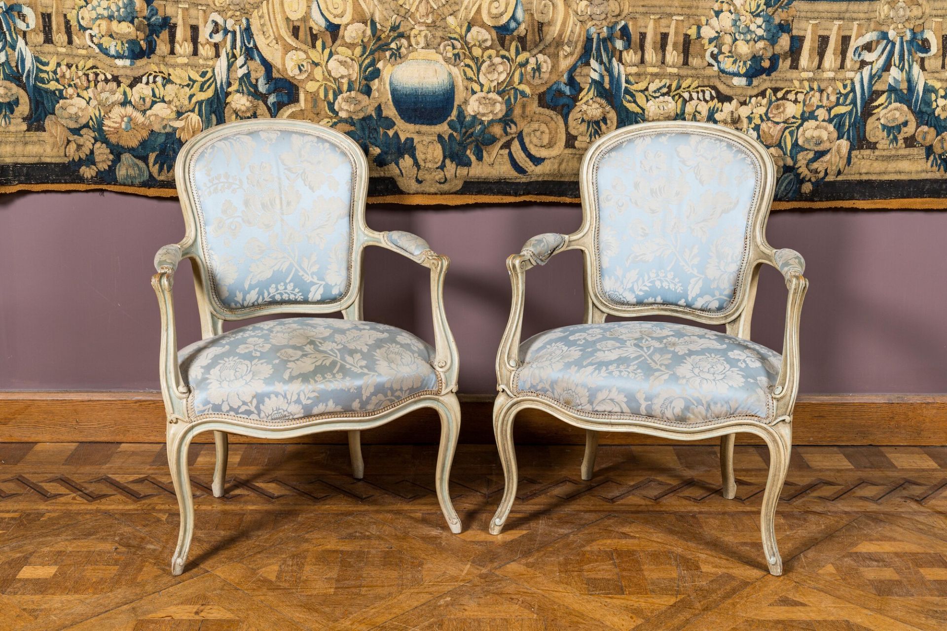 A pair of French Louis XV style patinated wooden armchairs, 20th C.