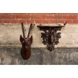 A carved wooden 'Black Forest' goat's head console and a carved oak head of a buck, Switzerland and/