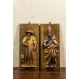 A pair of polychrome wooden reliefs with Saint Anthony and a bishop, 17th C.