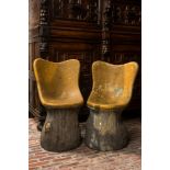 A pair of English naturalistically painted composite stone tree trunk chairs, mid 20th C.