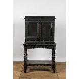 An ebonised wooden cabinet on stand with mirrored doors, 19th C.