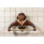 A rare polychromed wooden towel rack in the shape of a mischievous guy, 19th C.