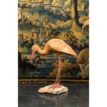 A polychrome plaster ibis on a stone base, 20th C.