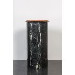 A black marble stand with orange-red marble top, 20th C.