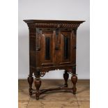 An oak and partly ebonised wooden two-door cupboard on foot, 19th C.