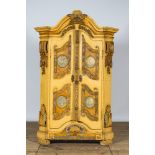 A German patinated wooden two-door cabinet with relief design and monogram R.K., 19th C.