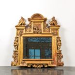 An architecturally carved and gilt wooden mirror with putti, 18/19th C.