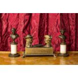 A pair of patinated bronze busts on a pedestal and a bronze ink set with playful heads, 19th C.