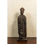A large wooden sculpture of Saint-Nicolas with a kneeling boy, 17th C.