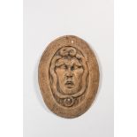 A large oval carved wooden 'Medusa' relief, 19th C.