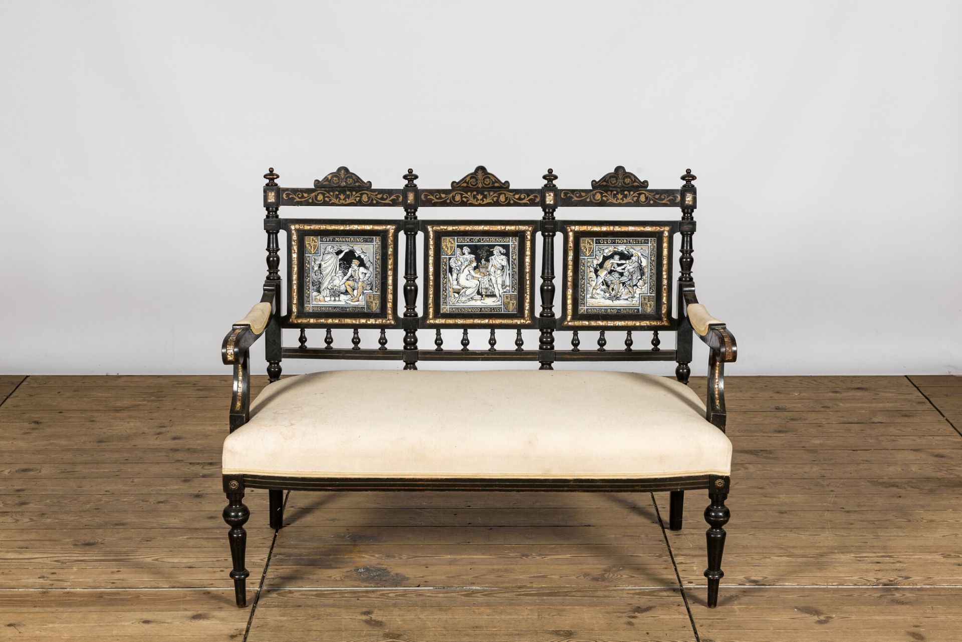 An English ebonised wooden sofa with mother-of-pearl inlaid and three Minton Waverley plaques by Joh