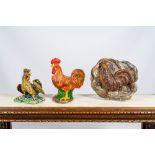 Two polychrome roosters in terracotta and composite stone and a wooden relief, 19/20th C.