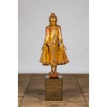 A tall inlaid gilt wooden figure of a standing Buddha, Thailand, 20th C.