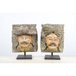 A pair of polychromed wooden heads on metal stands, India, 19/20th C.