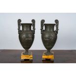 A pair of neoclassical style vases with charioteers on a Siena marble base, 19/20th C.