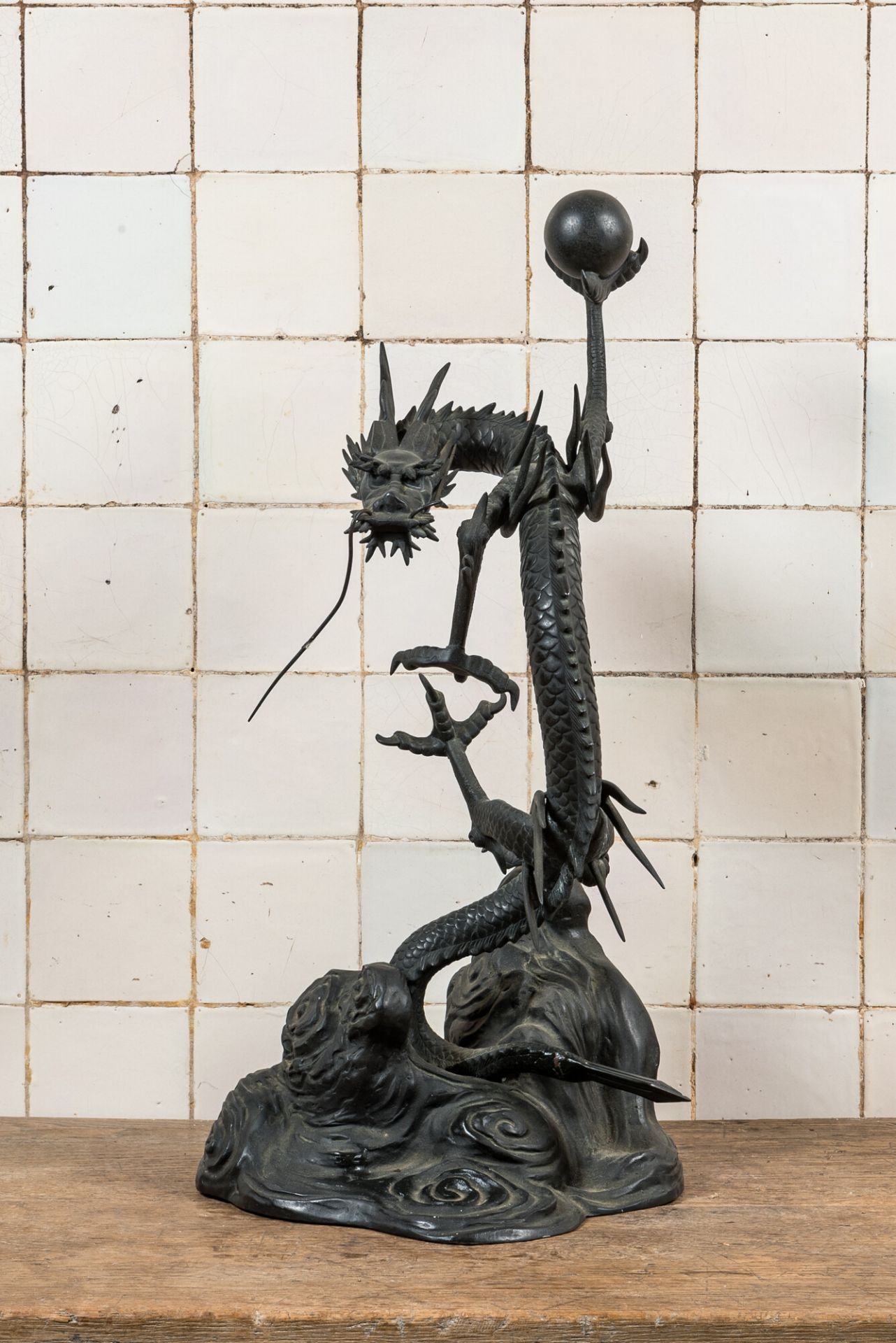 A large Japanse bronze okimono with a dragon holding the pearl of wisdom, Meiji, 19th C.