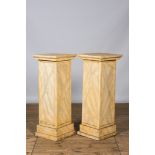 A pair of wooden 'faux marbre' pedestals, 20th C.