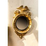 A gilt wooden eagle-topped butler mirror with ebonised border, ca. 1900