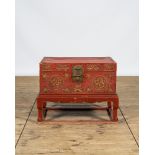 A Chinese red lacquered bronze-mounted travel trunk on foot, 20th C.