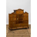 A German low ribbed wooden cabinet of drawers with a central door, 19th C.