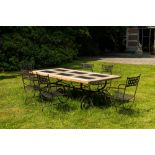 A wrought iron table with slate and wooden top with six chairs, 20th C.