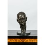 A patinated bronze head of a man on marble stand, illegibly signed and dated (19)29