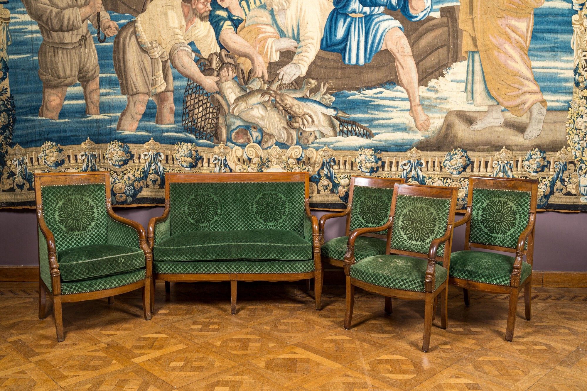 A green-upholstered carved wooden salon set with a two-seater, a fauteuil and three armchairs, 19th