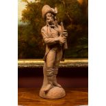 A terracotta figure of a flute player, 19th C.