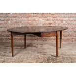 An oval English mahogany drop leaf table, 19th C.