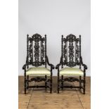 A pair of ebonised wooden armchairs with green silk upholstery, 19th C.