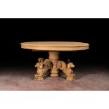 A bleached oak wooden oval table on a richly carved central base with dogs, 19th C.