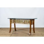 An Italian wooden table with gilt friezes after the antique with a thick glass top, 20th C.