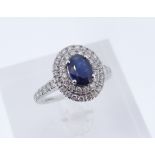 18CT WHITE GOLD SAPPHIRE & DIAMOND HALO RING, the central sapphire measuring 7 x 5mms approx.,