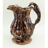 LARGE TREACLE GLAZED GAME JUG ATTRIBUTED TO SWANSEA POTTERIES the handle of greyhound form, the body