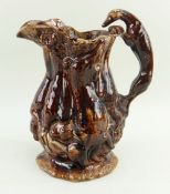 LARGE TREACLE GLAZED GAME JUG ATTRIBUTED TO SWANSEA POTTERIES the handle of greyhound form, the body
