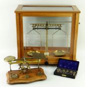 TWO BRASS SCALES, comprising wood cased scientific scale, brass and oak postal scale with set of