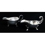 TWO GEORGE V SILVER SAUCE BOATS, one with cut card edge and flying scroll handle on hoof feet by