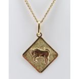 YELLOW METAL BULL PENDANT, indistinctly hallmarked, on 10k gold chain measuring 64cms, 12.6gms