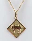 YELLOW METAL BULL PENDANT, indistinctly hallmarked, on 10k gold chain measuring 64cms, 12.6gms