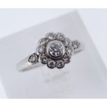 WHITE METAL DIAMOND CLUSTER RING, the central stone measuring 0.15cts approx., surrounded by a