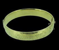 VINTAGE 1/5th NINE CARAT GOLD METAL CORE BANGLE with chased half decoration, in a vintage box