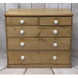 VICTORIAN STRIPPED PINE CHEST of two short over three long drawers with white porcelain knobs, on
