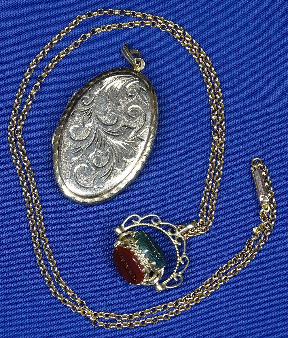 NINE CARAT GOLD OVAL LOCKET and a spinning open work fob, set with three...