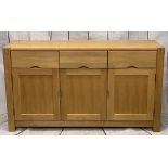 ULTRA-MODERN LIGHT OAK SIDEBOARD on substantial corner block supports, having three frieze drawers