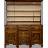 CIRCA 1860 ANGLESEY OAK DRESSER with breakfront, painted rack and three drawers over two cupboard