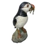 NEIL DALRYMPLE CERAMIC SCULPTURE OF A PUFFIN WITH CATCH - standing on a rocky base, incised