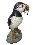 NEIL DALRYMPLE CERAMIC SCULPTURE OF A PUFFIN WITH CATCH - standing on a rocky base, incised