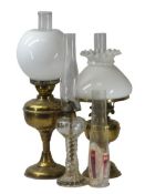 VINTAGE STYLE OIL LAMPS (3) to include two brass examples with white shades and glass funnels and