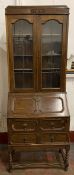 POLISHED OAK BUREAU BOOKCASE, the upper section with twin leaded glass doors, on barley twist